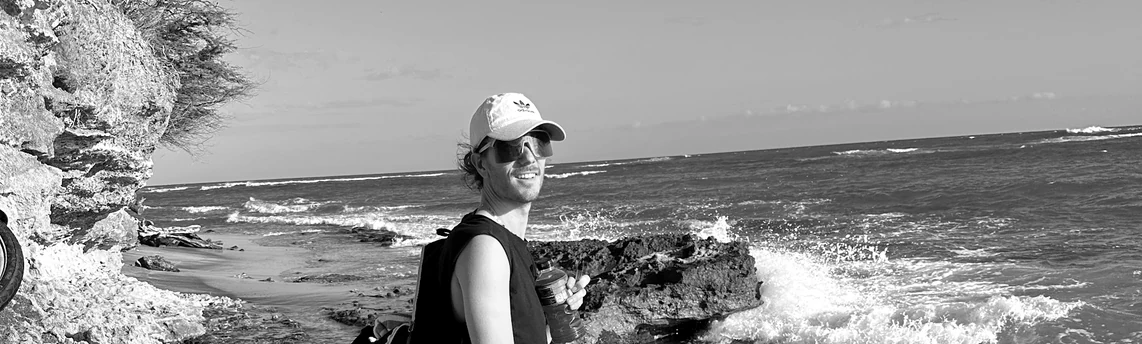 Derick standing beside a rocky shoreline